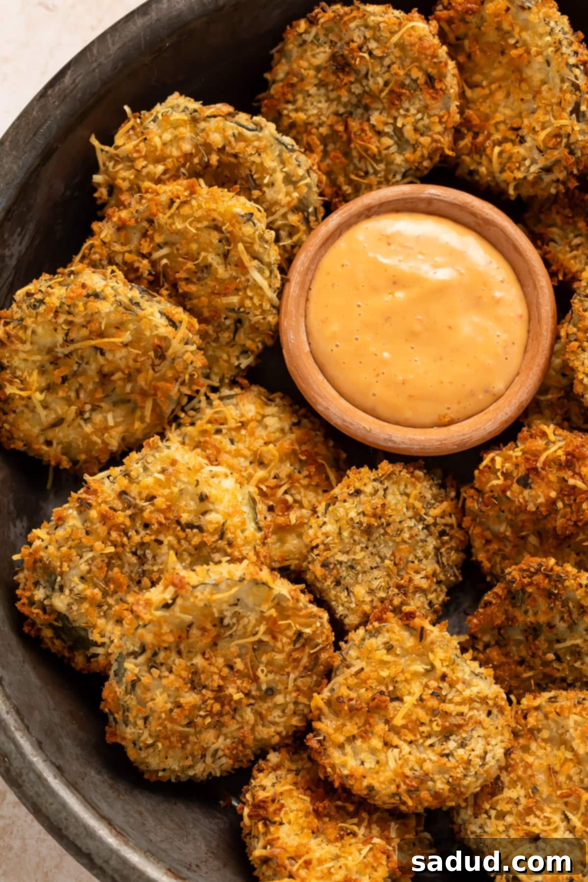 Golden Crisp Air Fryer Pickles 4 Close up of fried pickles in a black bowl with a small pot of spicy mayo for dipping.