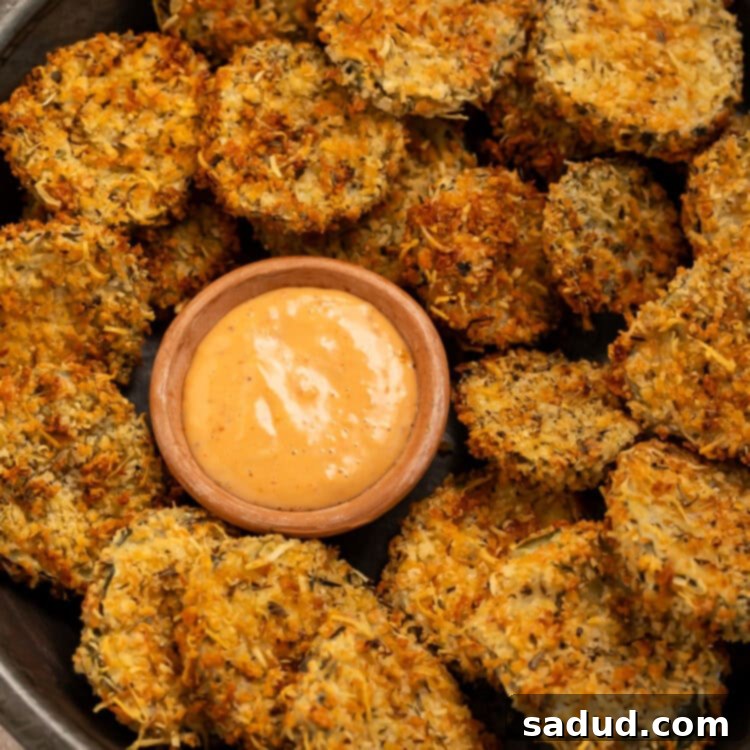 Golden Crisp Air Fryer Pickles 5 Black bowl of air fryer fried pickles with a small wooden bowl of creamy, spicy dipping sauce.