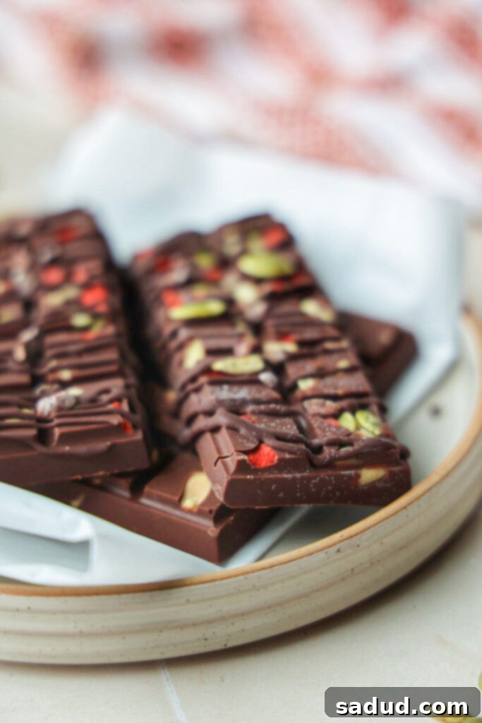 A close-up view of a single superfood chocolate bar, showing the texture of the dark chocolate and the embedded goji berries and seeds.