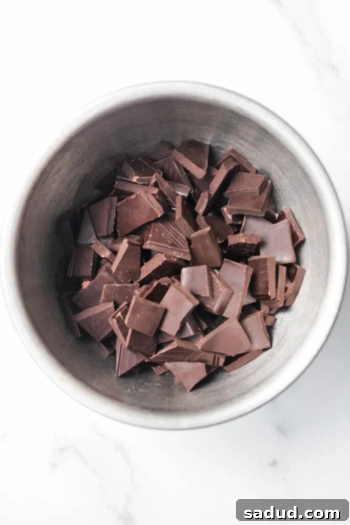Close-up of chocolate covered almonds being placed on parchment paper