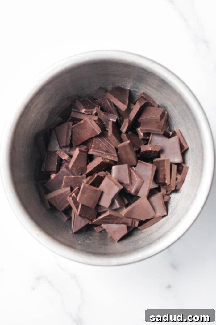 Chocolate pieces in a bowl, with parchment paper on a baking sheet.