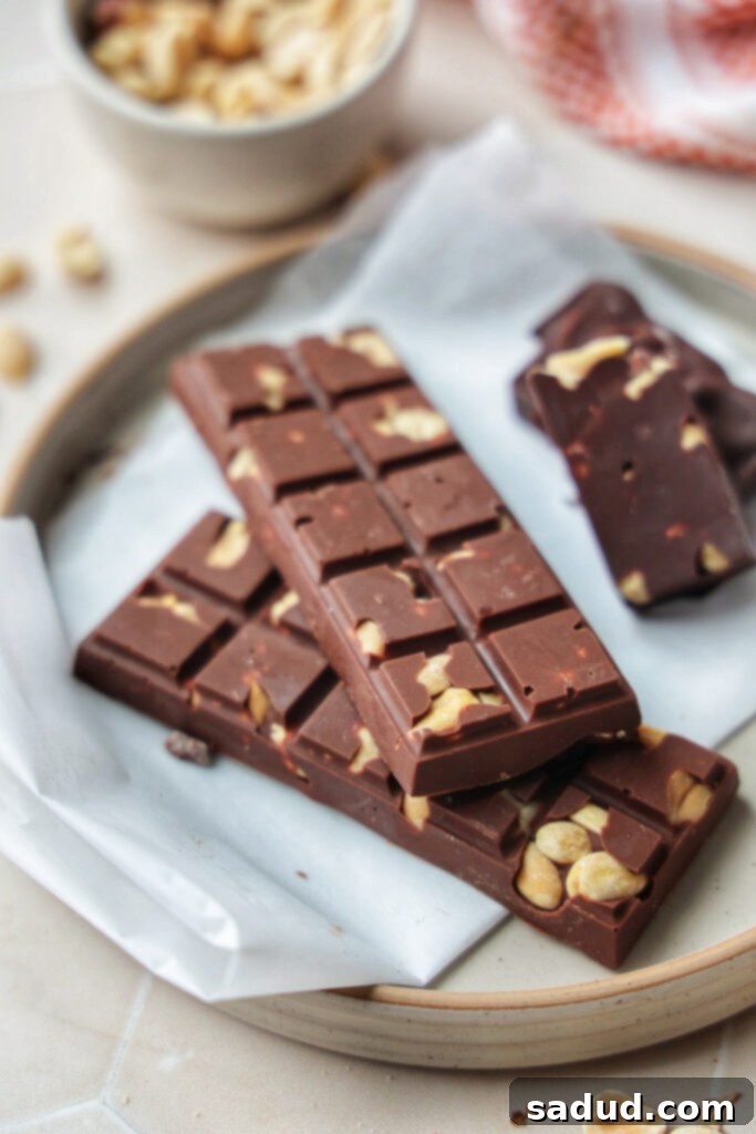 Close-up of a stack of healthier homemade Mr. Goodbar candy bars, showcasing the peanut chunks embedded in the chocolate.