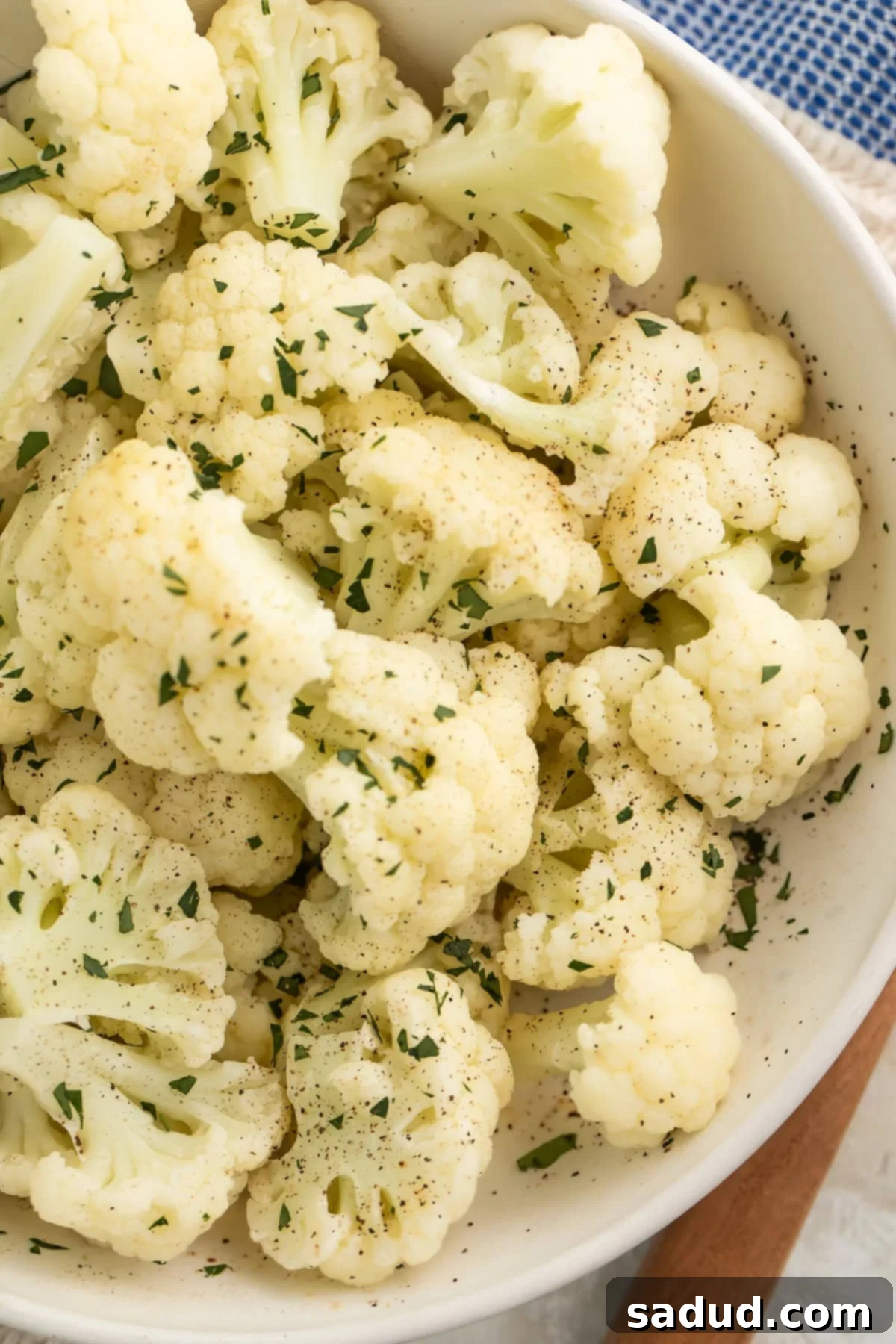 Simple Instant Pot Cauliflower 2 Close-up of a large white bowl holding tender florets of Instant Pot Cauliflower, ready to be seasoned or mashed.