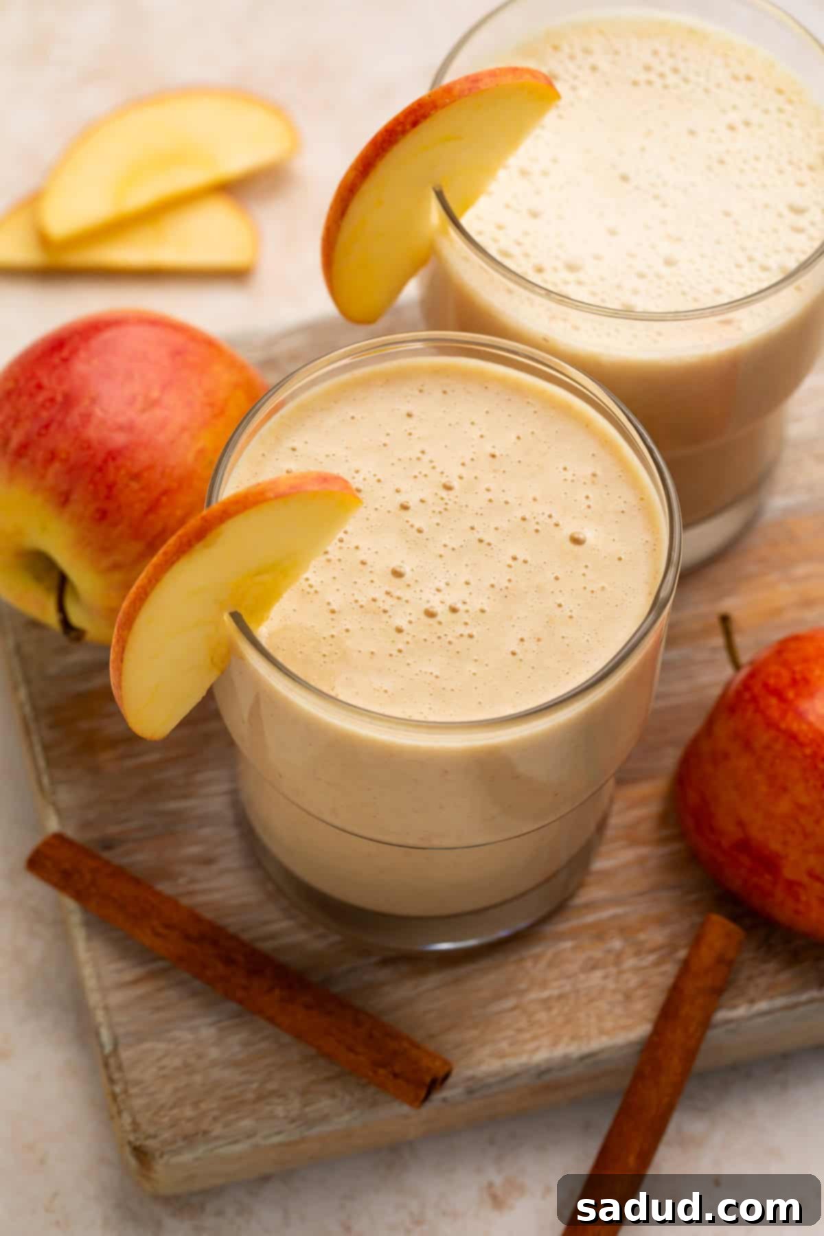 Overhead view of a pair of smoothies garnished with fresh apple.