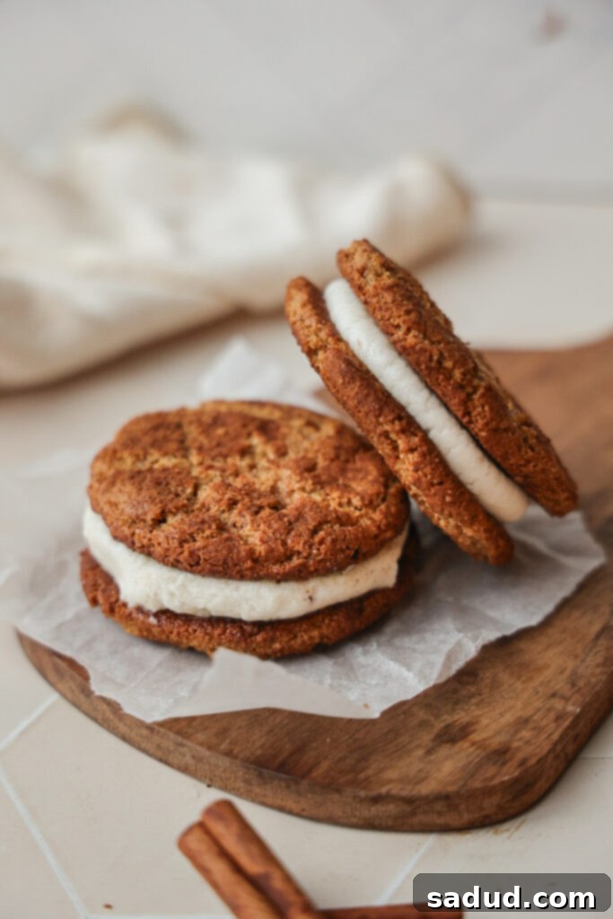 Paleo Gluten Free Snickerdoodle Creme Pies 3 Two soft snickerdoodle creme pies, with the creamy filling visible between the cookies.