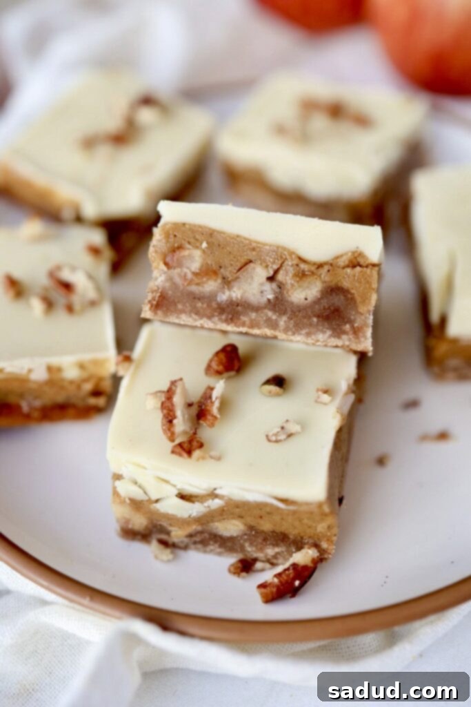 A plate of golden-brown caramel apple bars topped with white chocolate drizzle, ready to be enjoyed.