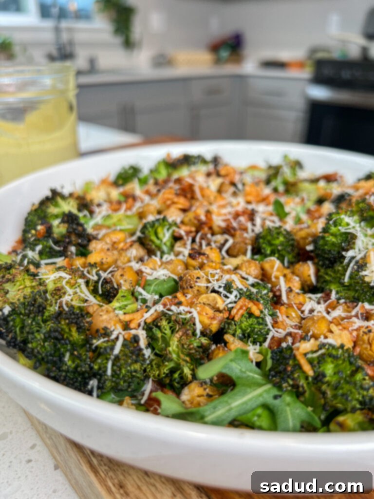 A vibrant bowl of roasted broccoli miso caesar salad topped with crispy quinoa and fresh herbs, showcasing its rich textures and inviting colors.