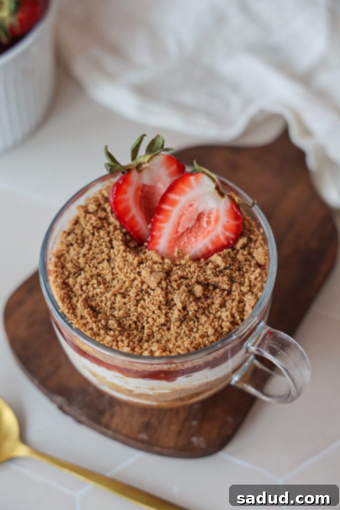 A simple yet elegant strawberry yogurt bowl, generously topped with fresh whole and sliced strawberries, and a sprinkle of cookie crumbles, presented for a healthy snack or breakfast.
