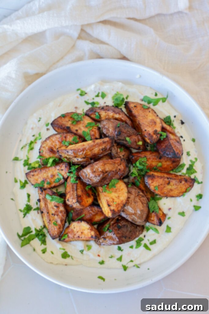 Golden Roasted Greek Potatoes with Creamy Feta 2 A plate of roasted Greek Potatoes with Whipped Feta garnished with fresh parsley.