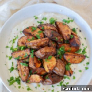 Golden Roasted Greek Potatoes with Creamy Feta 3 A plate of roasted Greek Potatoes with Whipped Feta garnished with fresh parsley.