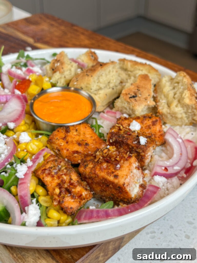 A harissa avocado bowl with salmon and vibrant vegetables.