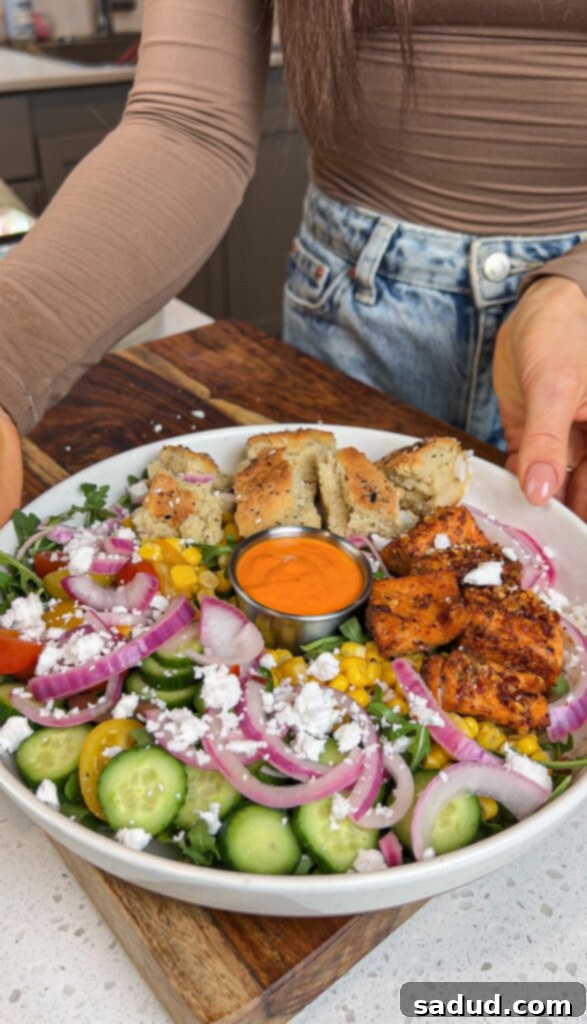 A harissa avocado bowl with blackened air fried salmon bites, ready to eat.