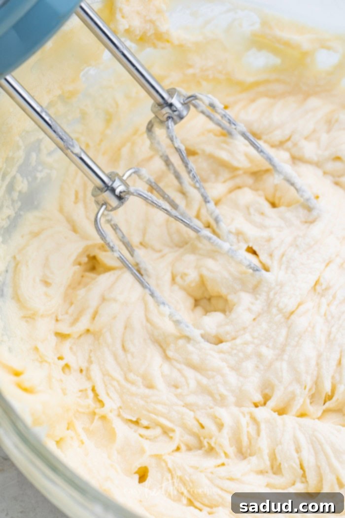 Keto cream cheese frosting being mixed in a large bowl, showing its smooth texture.