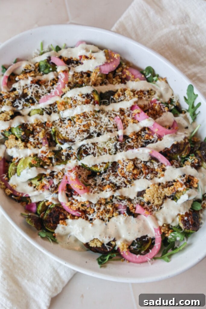 Tahini Caesar Brussels Sprouts Salad 2 A beautifully plated Tahini Caesar Brussels Sprouts Salad with roasted sprouts, pickled onions, and crispy quinoa.