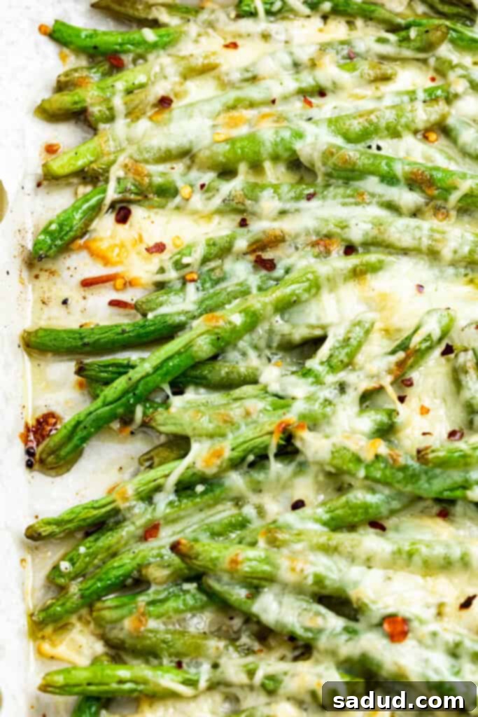 Baked Keto Cheesy Green Beans 2 keto green beans on a baking sheet with red pepper flakes on top