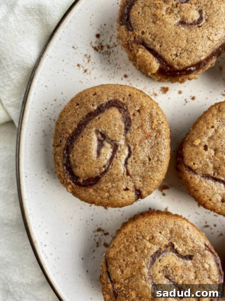 Close-up shot of a cinnamon roll muffin showing the beautiful swirl pattern on top.