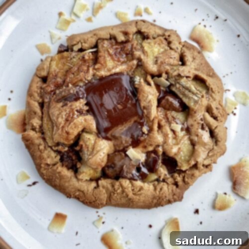 Two caramelized banana tarts, one sliced open to show the gooey filling.