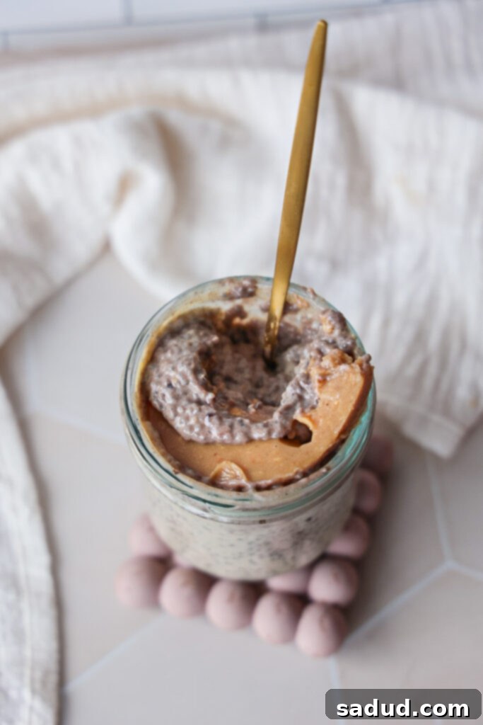 A jar of creamy chia pudding with peanut butter magic shell with coconut milk and yogurt.