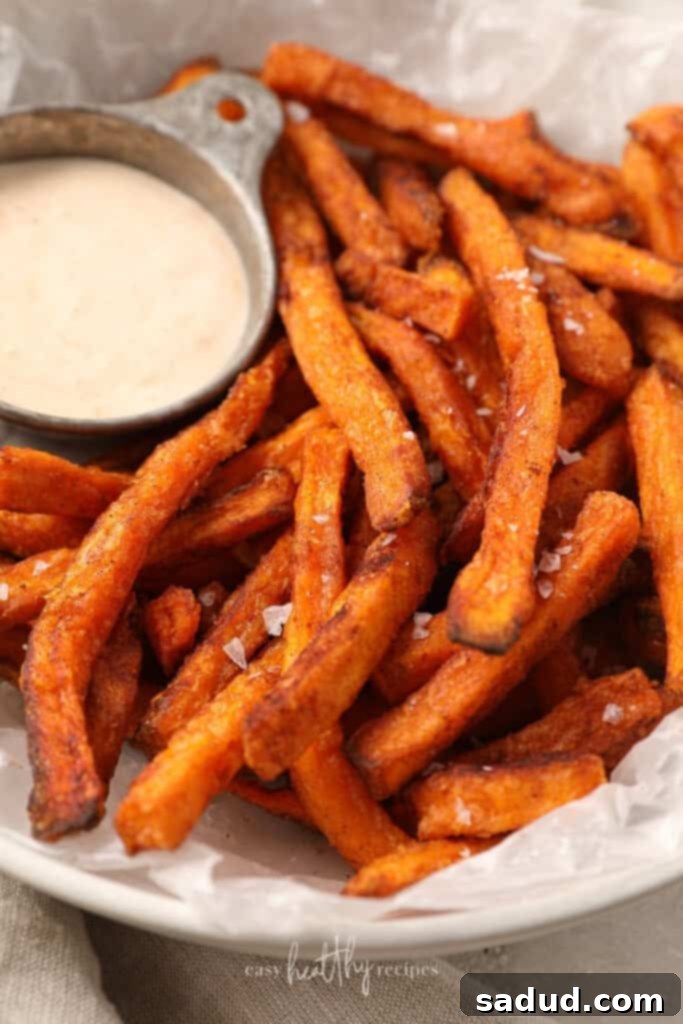 Crispy Air Fryer Sweet Potato Fries from Frozen 4 Close up of sweet potato fries in a white bowl, showing crispy texture and seasoning