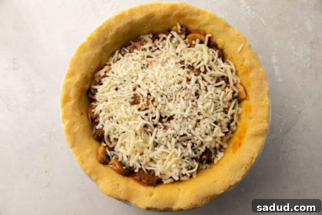 A beautifully prepared uncooked whole keto meat pie, nestled perfectly in its keto pie crust, ready for baking.