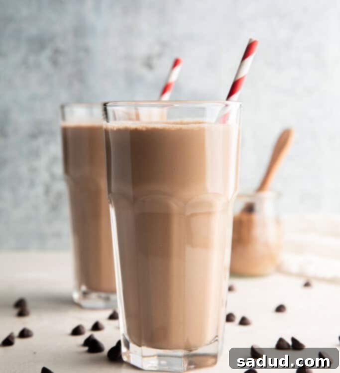 Two glasses of rich keto chocolate milk with striped straws, ready to be enjoyed.