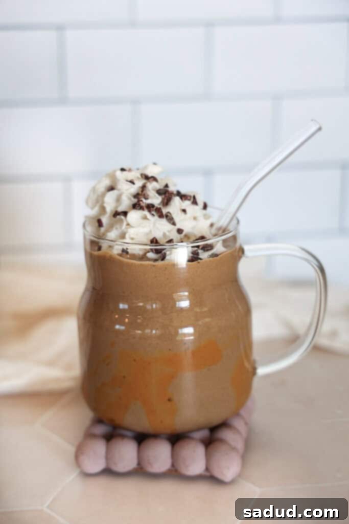 A coffee protein shake with whipped cream, garnished with cacao nibs.