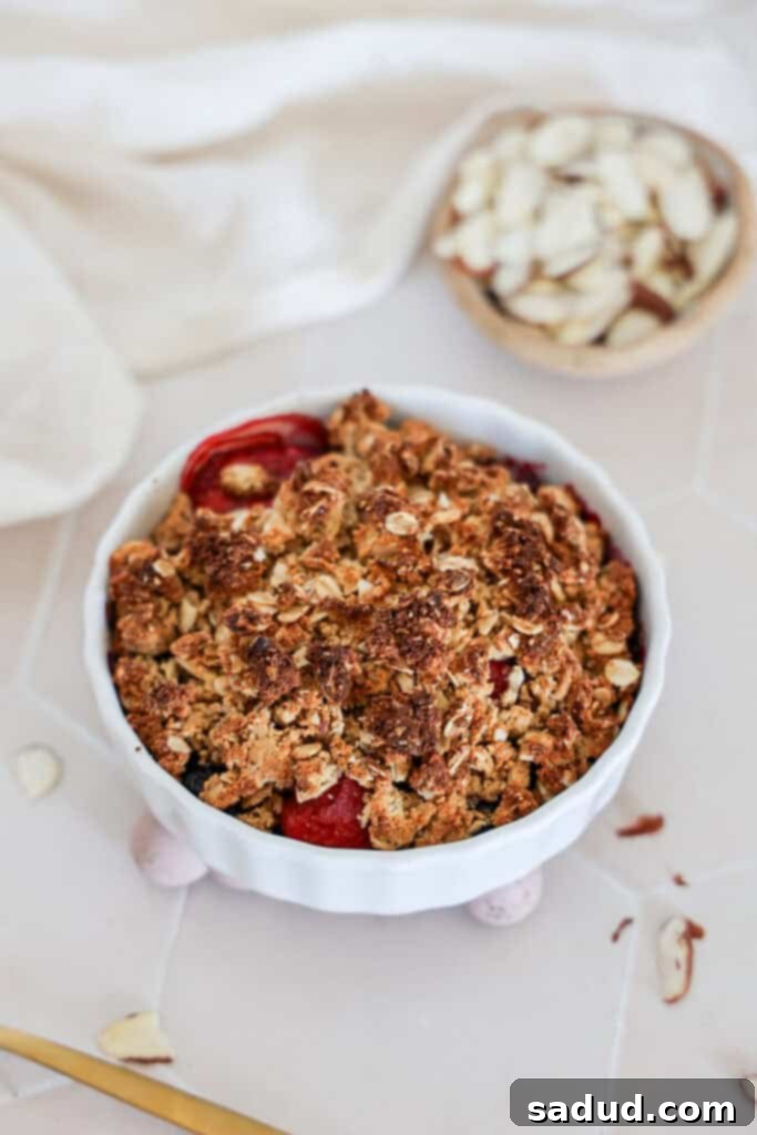 A close-up of a berry breakfast crumble/crisp, highlighting the golden oat topping.