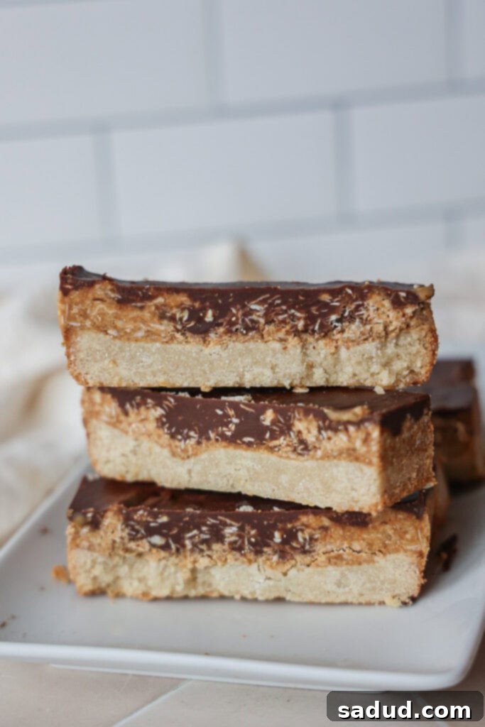 Coconut Caramel Chocolate Bars 3 A stack of coconut cookie bars.