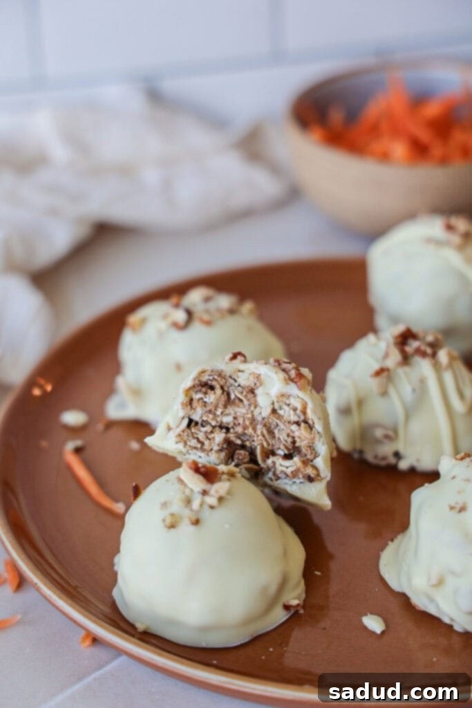 A plate of healthy carrot cake bites/truffles, some with white chocolate coating, some plain, showcasing their natural, wholesome texture.