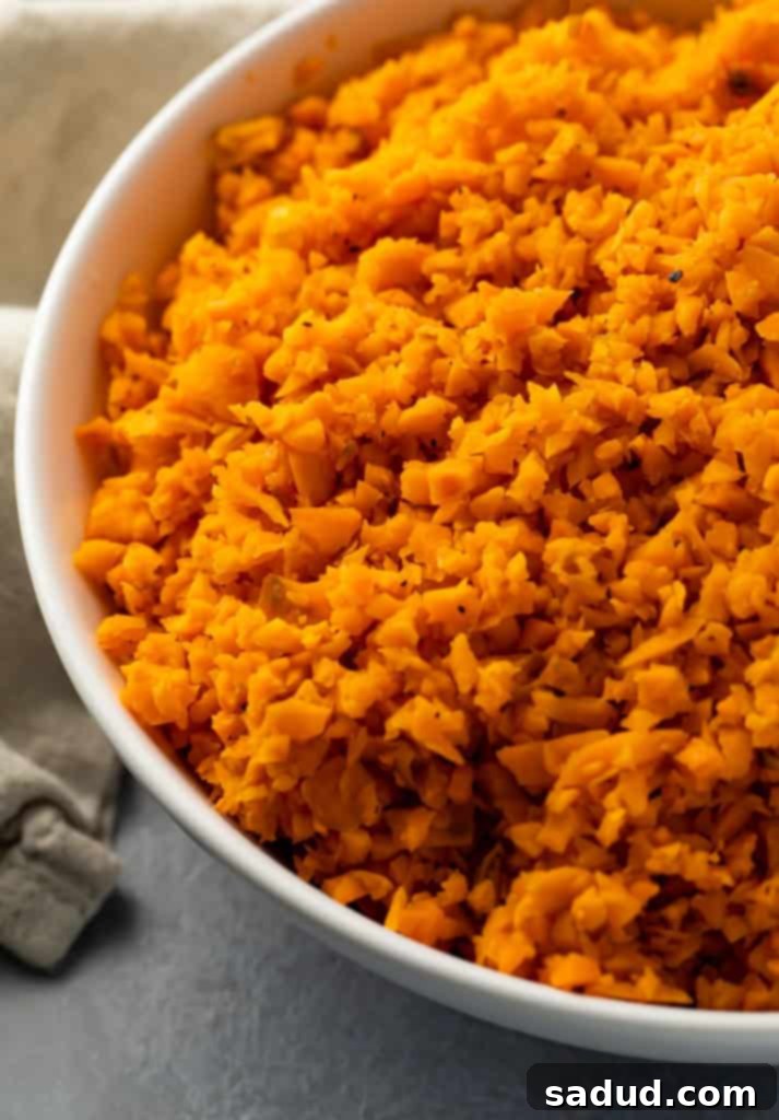 A vibrant bowl of freshly cooked sweet potato rice, ready to be served as a healthy side dish or meal base.