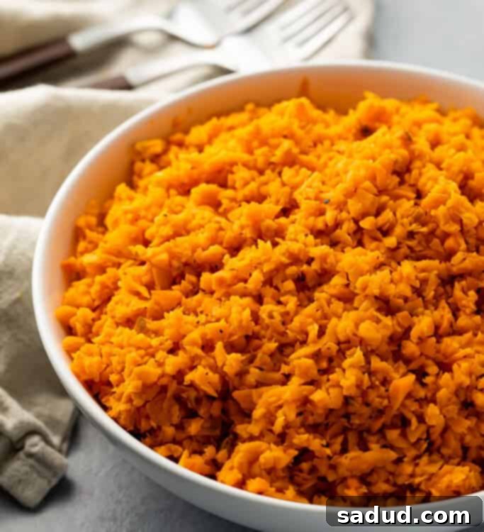 White bowl of bright orange sweet potato rice