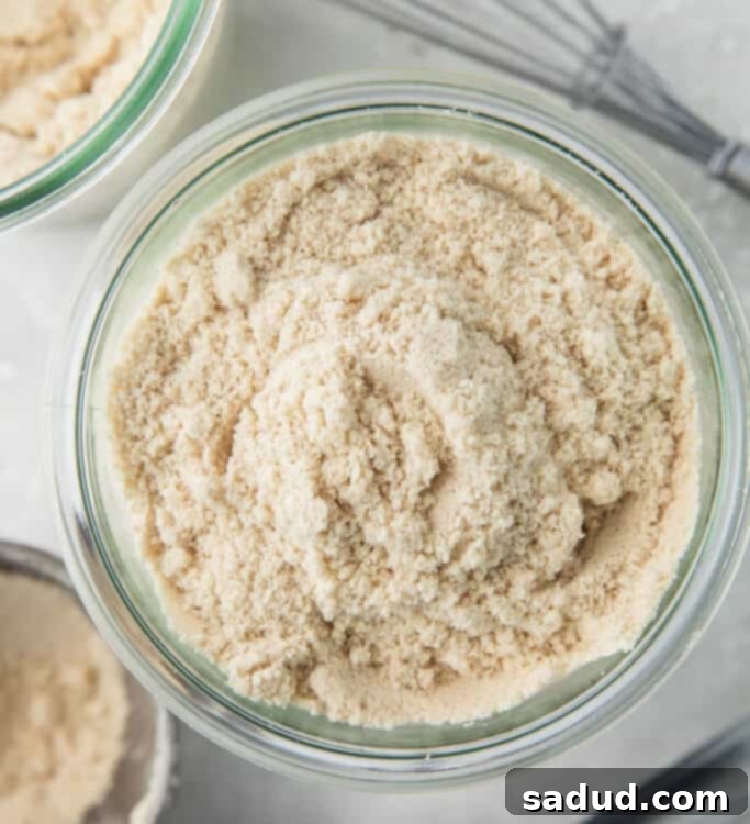 Keto flour mix in a glass jar surrounded by cooking utensils