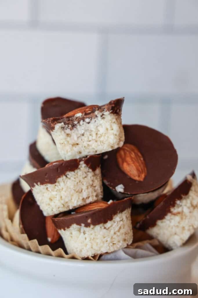 A bowl of healthy, vegan almond joys, glistening with chocolate and coconut.