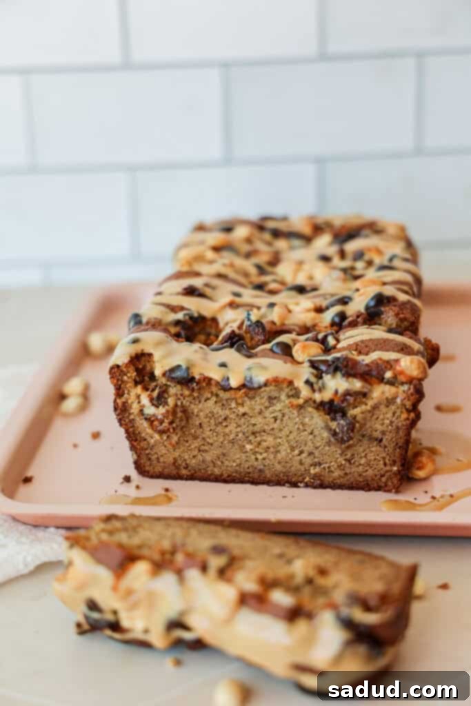 A delicious loaf of gluten-free almond flour banana bread topped with peanut butter drizzle and chocolate chips.