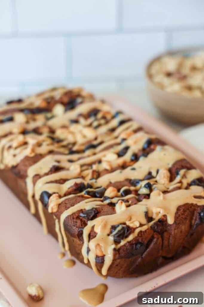 A slice of almond flour banana bread with chocolate chips and peanut butter drizzle on a plate.