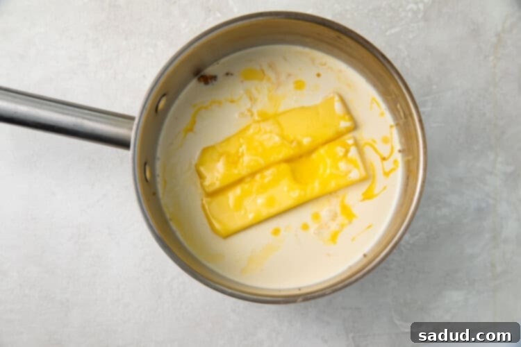 Heavy cream and butter simmering in a silver saucepan for the frosting base.