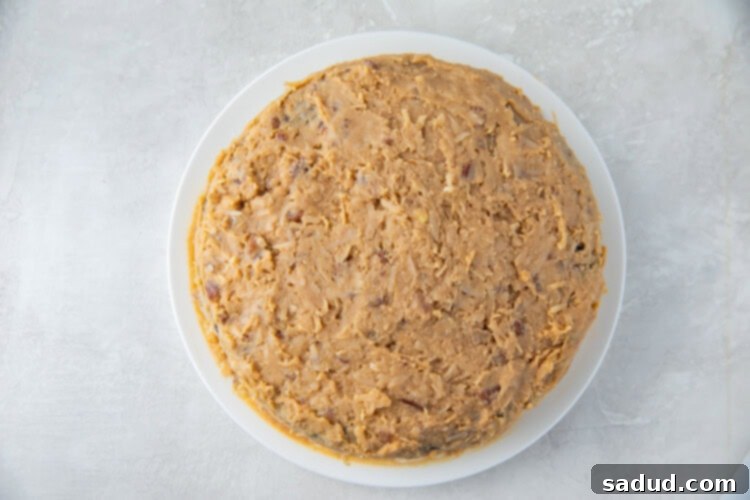 A freshly frosted two-layer keto German chocolate cake, ready to be sliced and served.