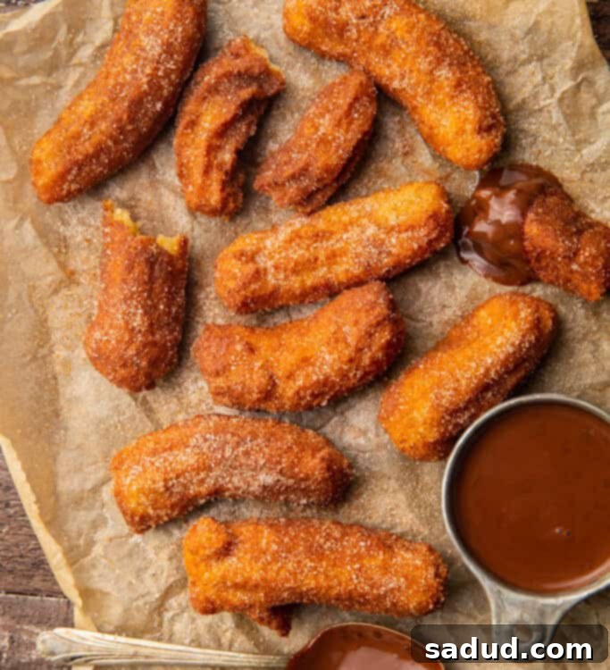 Guilt-Free Churros 4 Keto churros next to a small bowl of chocolate sauce with a chocolate covered spoon on parchment paper