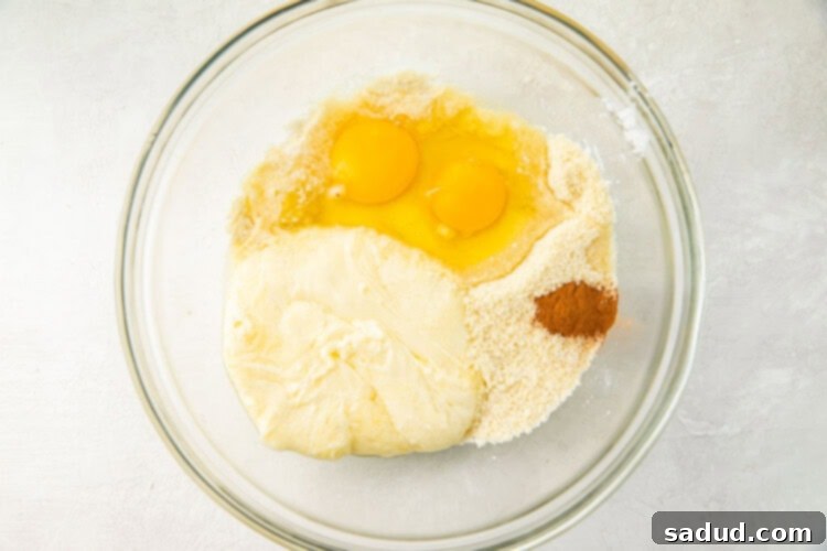 Cinnamon, eggs, almond flour, erythritol, and baking powder in a glass bowl