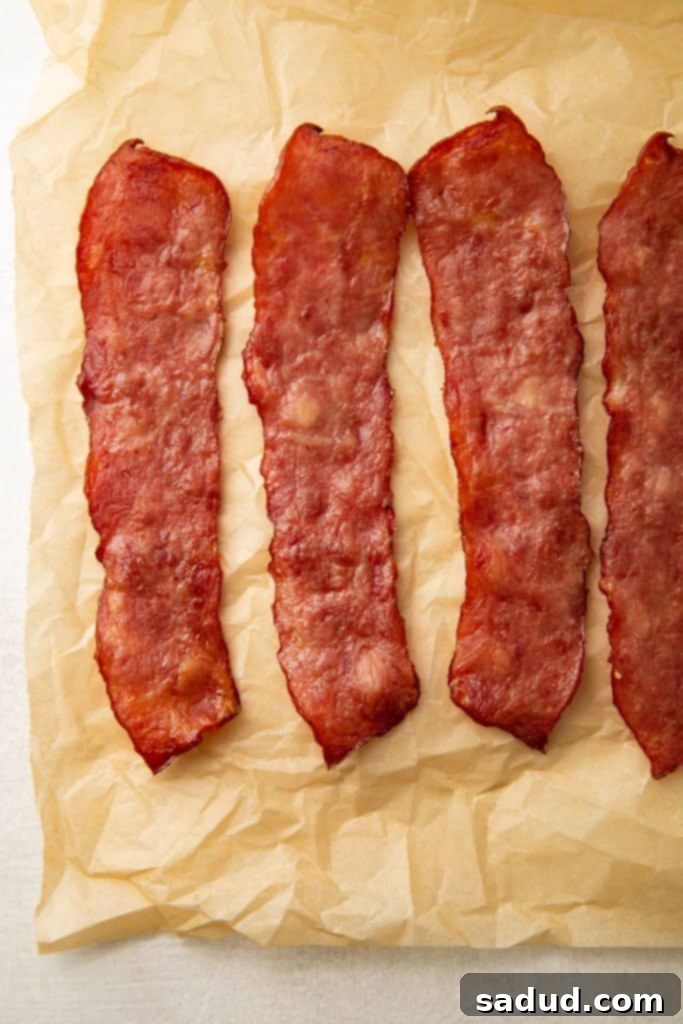 3 and a half slices of turkey bacon on a sheet of parchment paper
