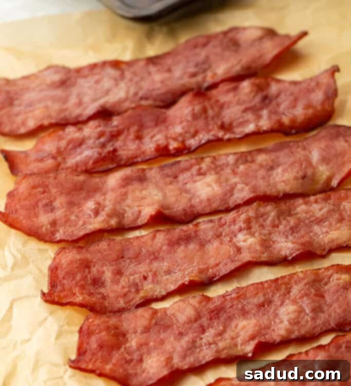 6 slices of turkey bacon laid diagonally across a sheet of parchment paper