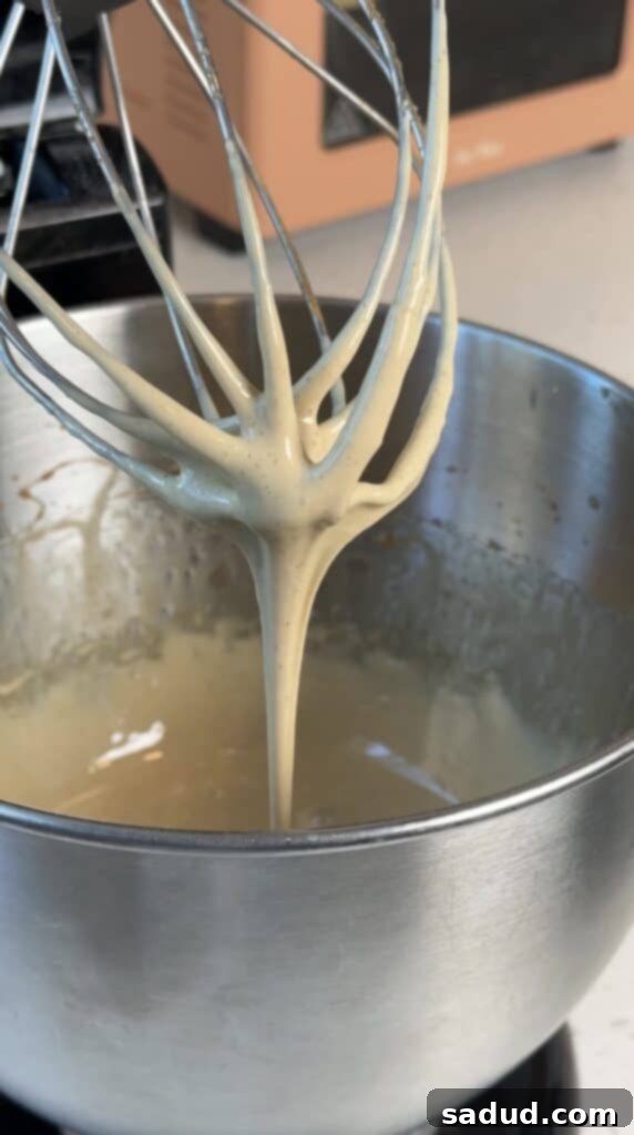 Silken Honey Dream 5 A step-by-step image of honey being poured into a stand mixer bowl, preparing for the whipping process.