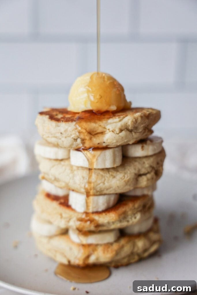 A stack of fluffy, gluten-free, dairy-free, nut-free pancakes with pure maple syrup and butter.