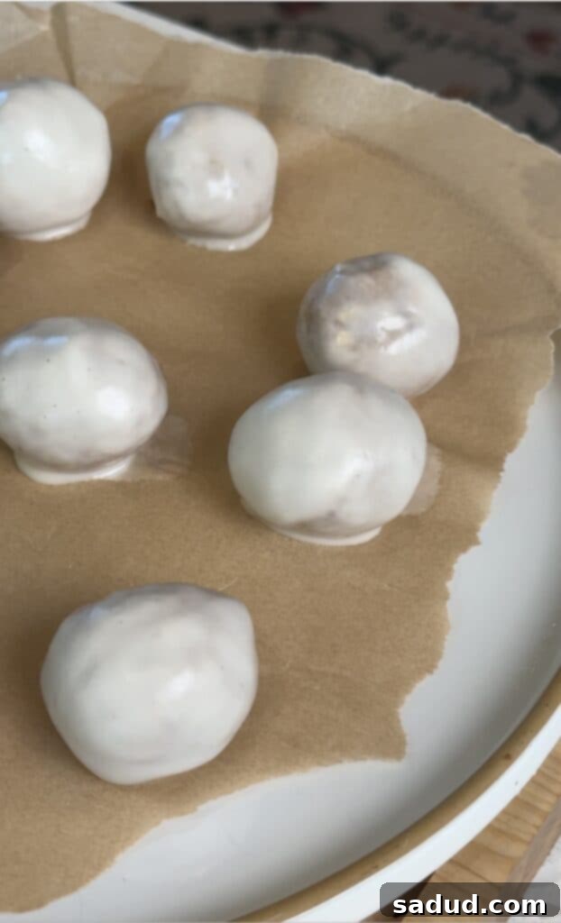 Rolling the no-bake donut hole dough into uniform, perfectly round balls before glazing.