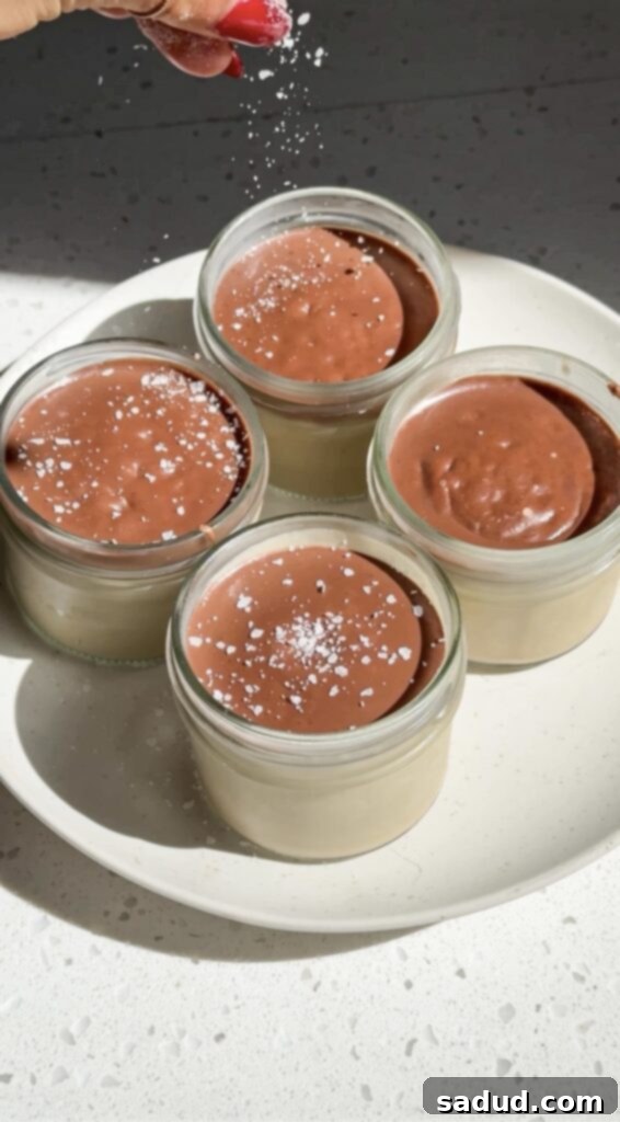 Guilt-Free Vegan Tiramisu Pudding Cups 3 Two jars of healthy vegan tiramisu cups, one topped with ganache and sea salt, showcasing the creamy layers.