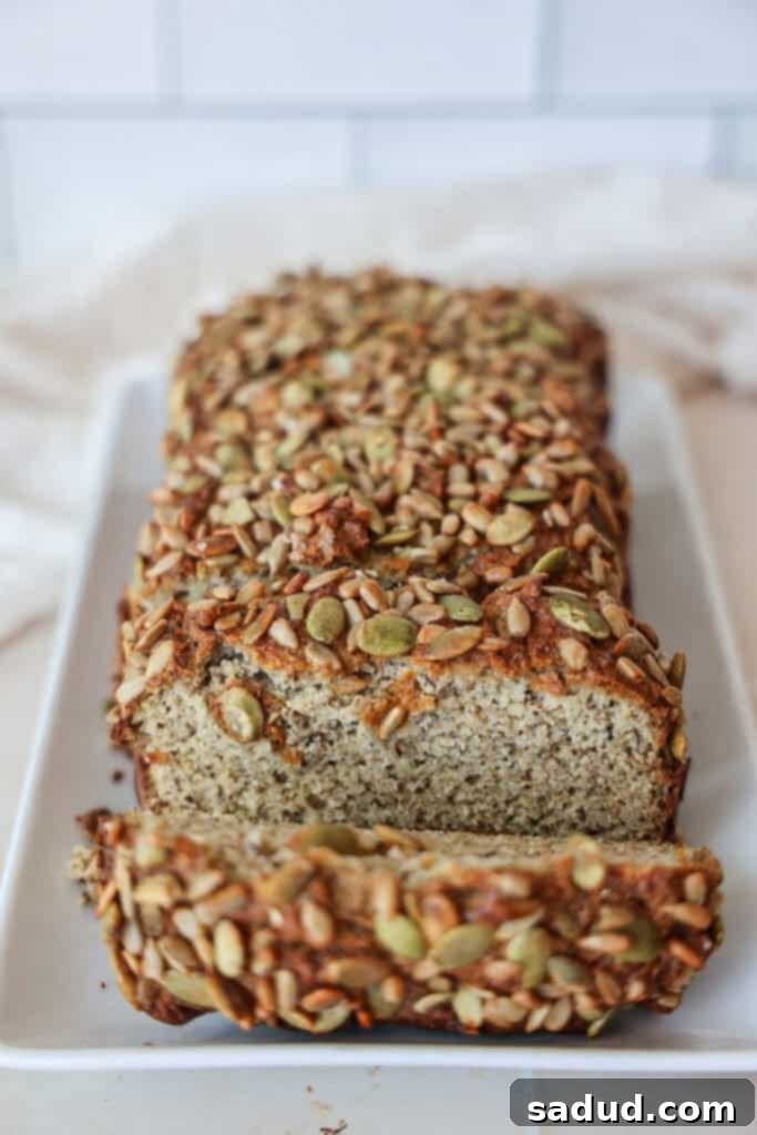 A slice of fluffy paleo, grain-free, gluten-free sandwich bread topped with mixed seeds.