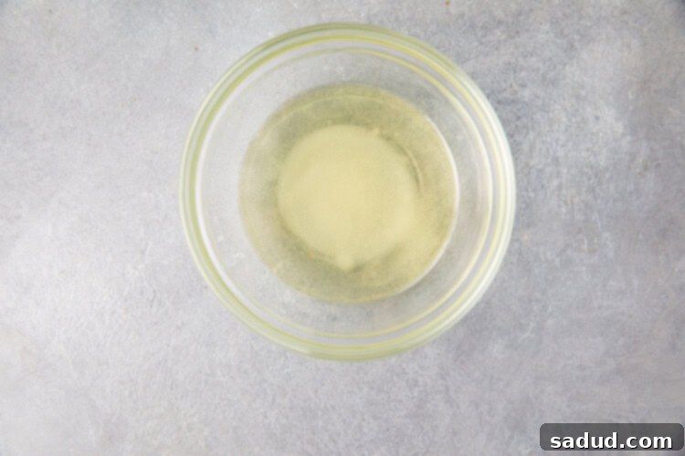 Rice vinegar, salt, white sugar, and oil in a small glass bowl for Instant Pot sushi rice