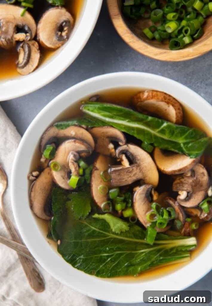 Overhead shot of a vibrant bowl of Chinese vegetable soup with fresh garnishes.