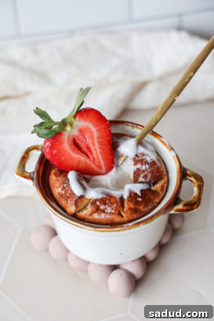A healthy, high protein, breakfast cheesecake souffle with fresh strawberries and a drizzle of yogurt on top.