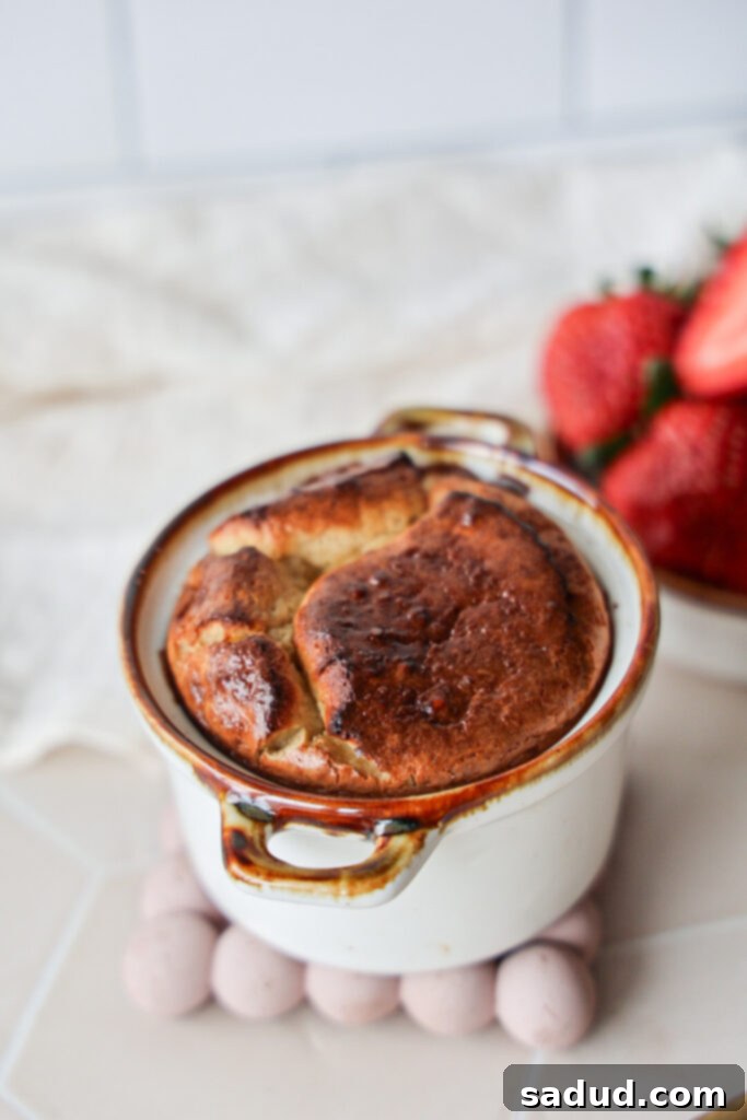 A healthy breakfast cheesecake souffle topped with fresh strawberries, ready to be enjoyed.